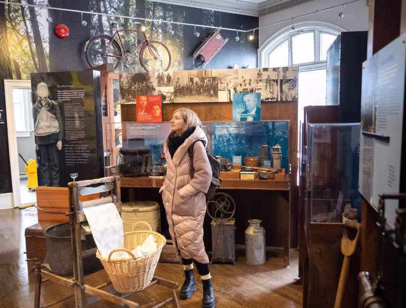 Person in a museum exhibit with various artifacts on display.