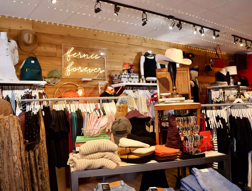 Clothing store interior with racks of clothes and table displays.